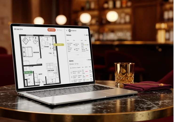 DzLink -How internet monitoring works: Laptop on a bar table showing a smart home security system floor plan and alarms.